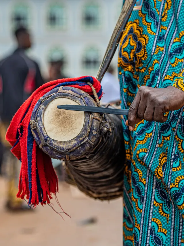 A hand beating a talking drum