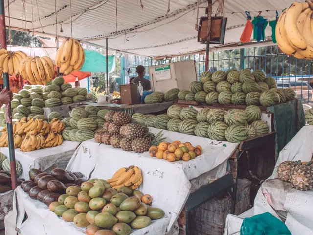 A Nairobi market stall piled with bananas, avocados, mangoes and melons